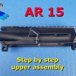 AR-15 Upper Assembly – stripped upper receiver on blue background for step-by-step tutorial
