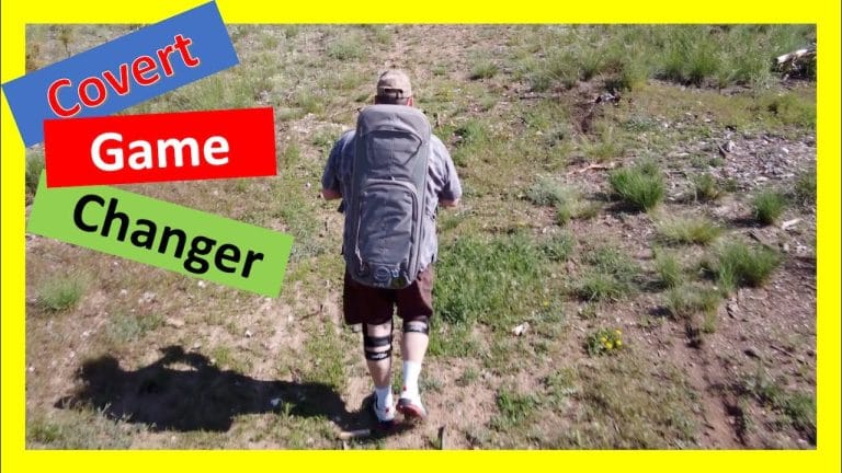 Person hiking uphill with a Savior Covert 34 rifle case worn as a backpack; overlaid text says “Covert Game Changer.”